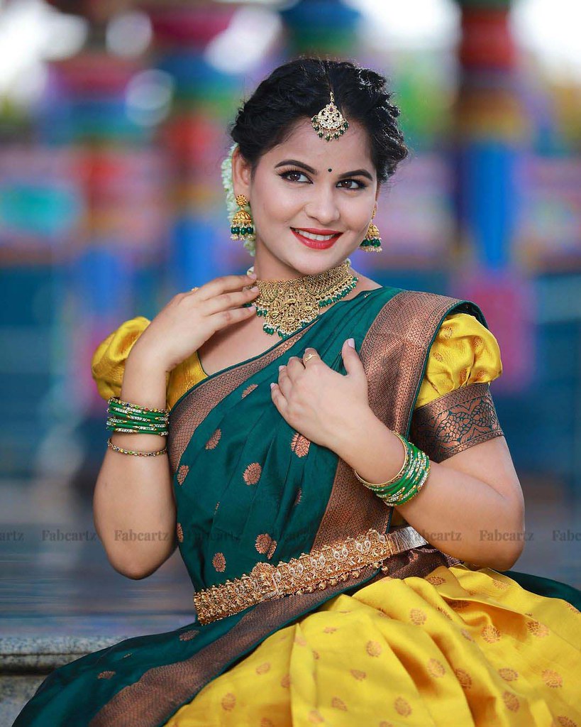 Anjena poses in a traditional outfit during a photoshoot
